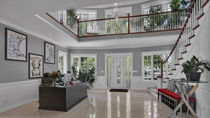 A spacious foyer with a high ceiling, a central reception desk, and a staircase leading to an upper level. - Somerset Bed and Breakfast (Niagara-on-the-Lake)