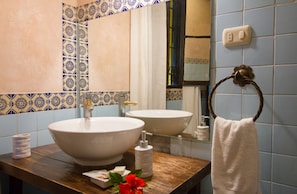 A bathroom with two sinks, a mirror, and a towel ring. - Hotel Monasterio (Antigua Guatemala)