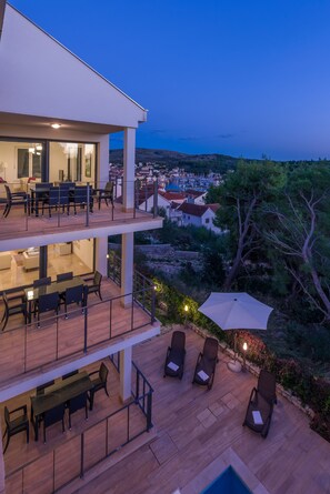 A modern two-story house with a balcony, outdoor seating, and a view of the sea. - Villa Old Mill (Milna)