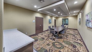A conference room with a large table, chairs, a carpeted floor, and a door labeled 'STORAGE'. - Holiday Inn Express & Suites Carrizo Springs by IHG (Carrizo Springs)