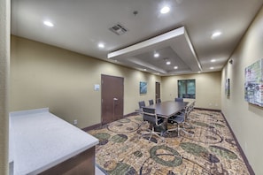 A conference room with a large table, chairs, a carpeted floor, and a door labeled 'STORAGE'. - Holiday Inn Express & Suites Carrizo Springs by IHG (Carrizo Springs)