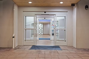 A hotel entrance with a revolving door, a doormat, and a tiled floor. - Holiday Inn Express & Suites New Cumberland by IHG (New Cumberland)