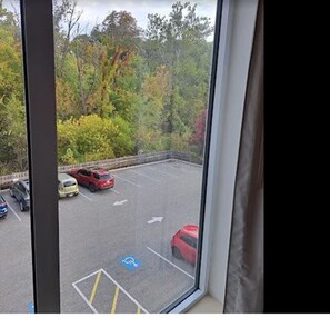 A parking lot with cars and a blue handicapped parking sign.