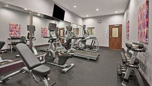 A modern gym with various exercise equipment, including treadmills, stationary bikes, and weight machines.