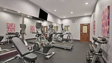 A modern gym with various exercise equipment, including treadmills, stationary bikes, and weight machines.