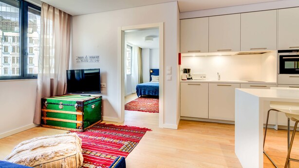 A modern apartment with a kitchen, a living area with a large window, and a view of the city. - LSA Liberdade by Numa (Lisbon)