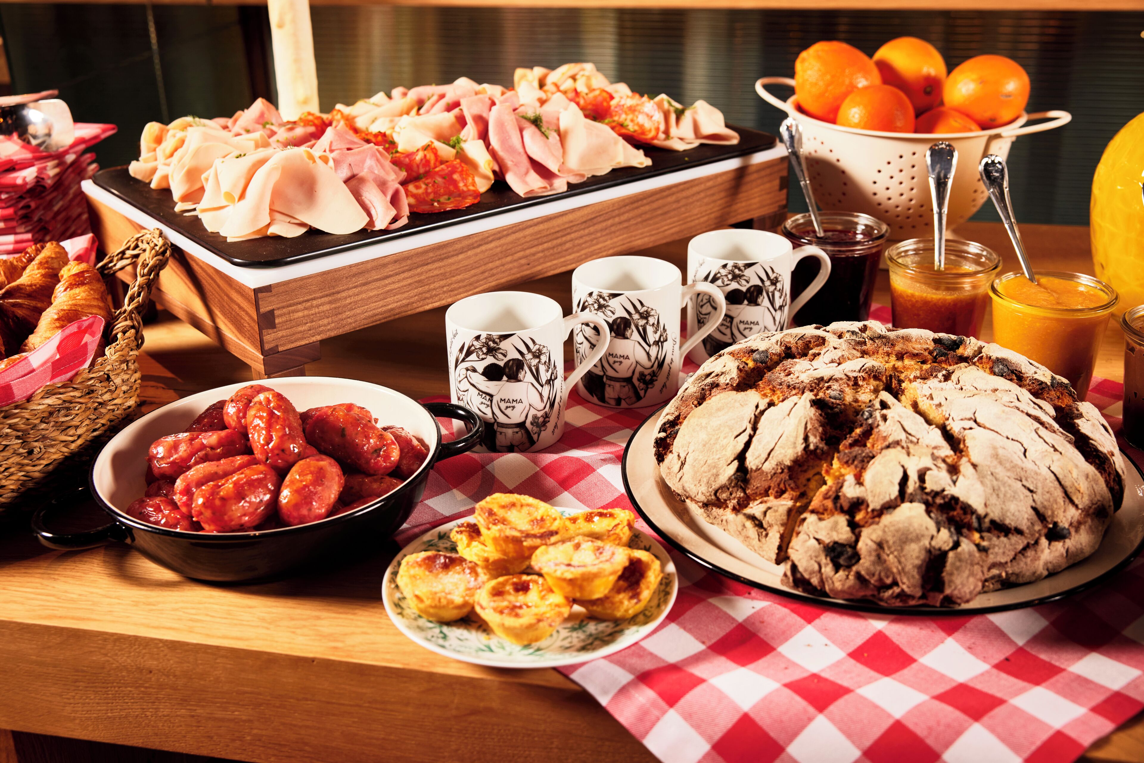 Une table de buffet proposant une variété de plats, notamment des pâtisseries, des viandes et un grand gâteau.