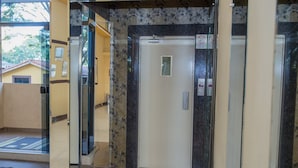 An elevator with a glass door, a control panel, and a sign indicating no smoking. - Villa Iguaçu Palace Hotel (Foz do Iguaçu)