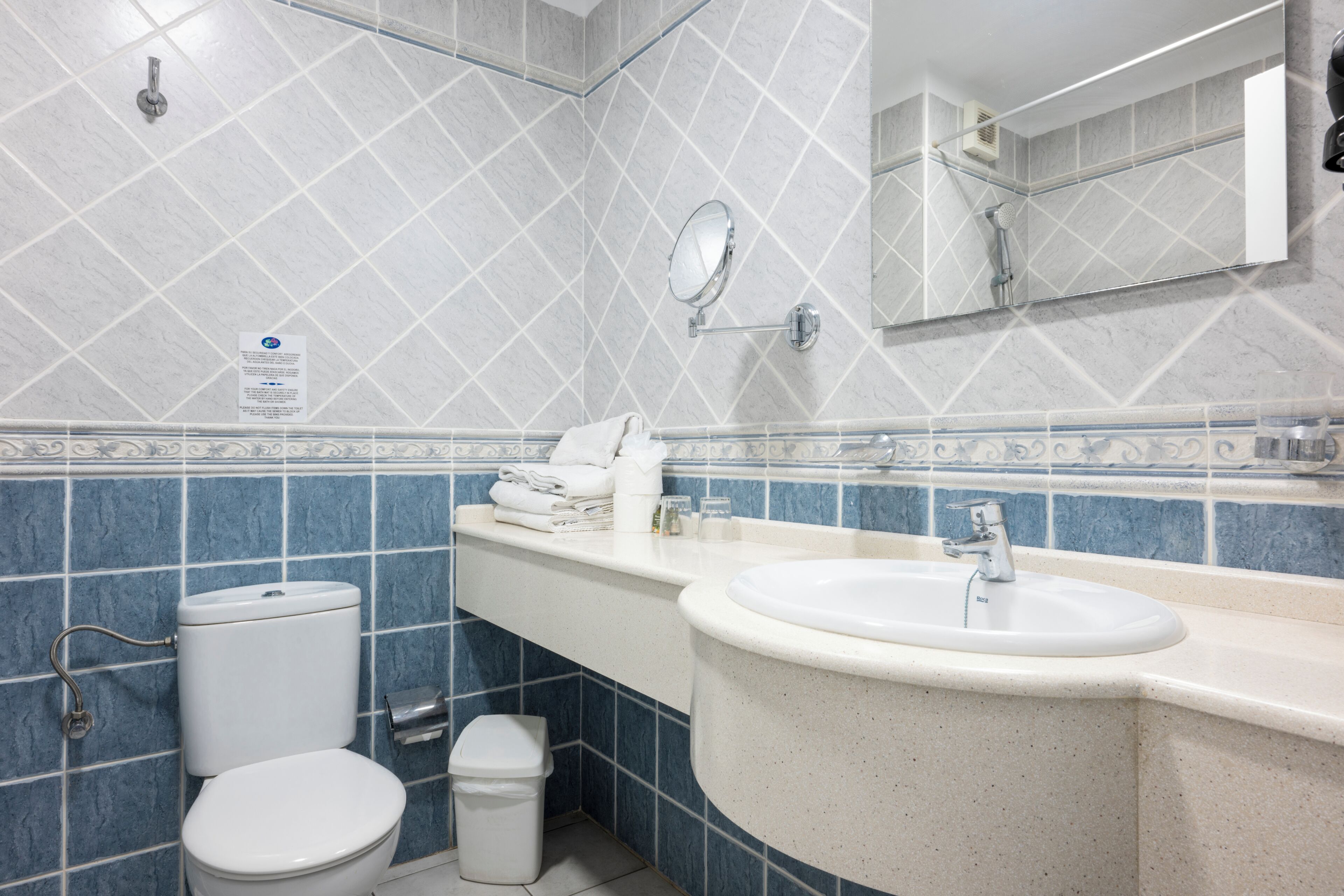 Un baño con inodoro, lavabo y espejo.