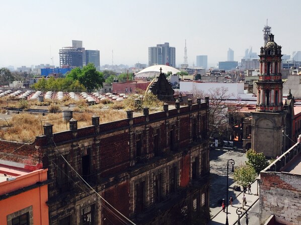 Un paisaje urbano con arquitectura histórica, incluyendo una imponente torre del reloj y una estructura en forma de cúpula.