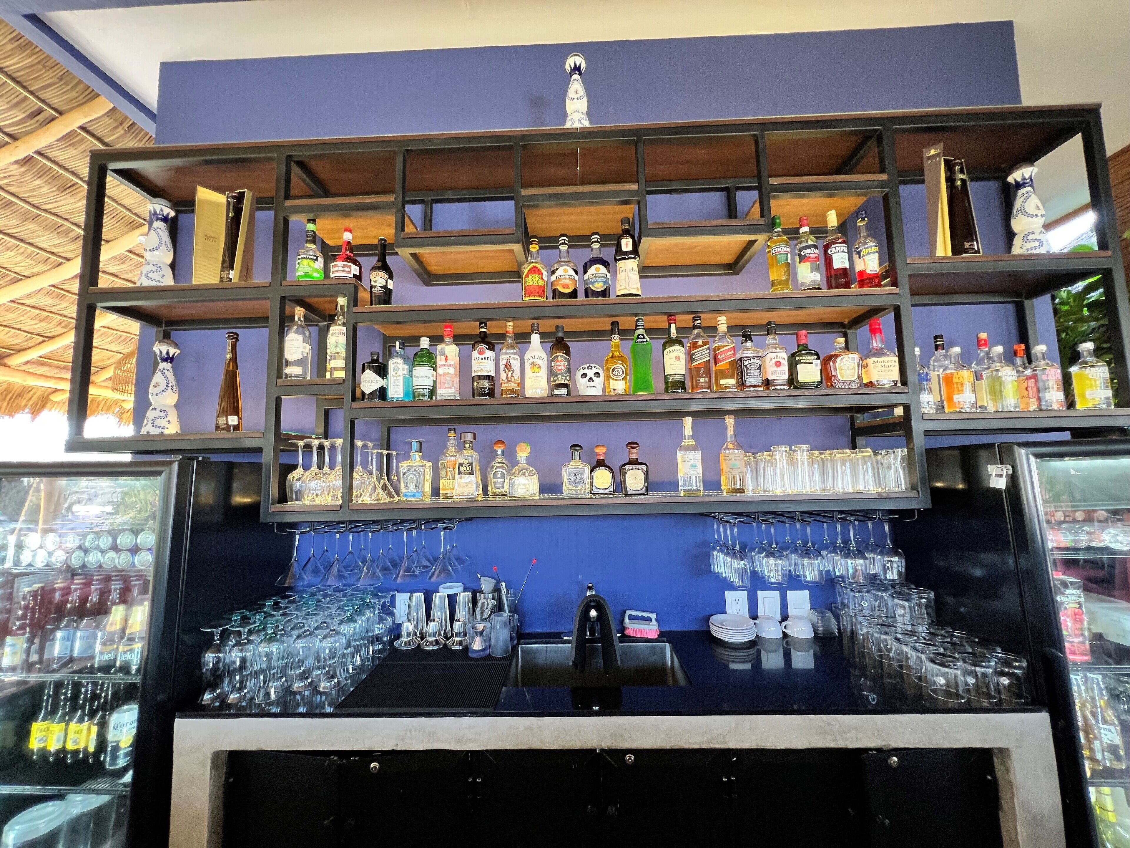 A bar area with shelves of liquor bottles and glasses.