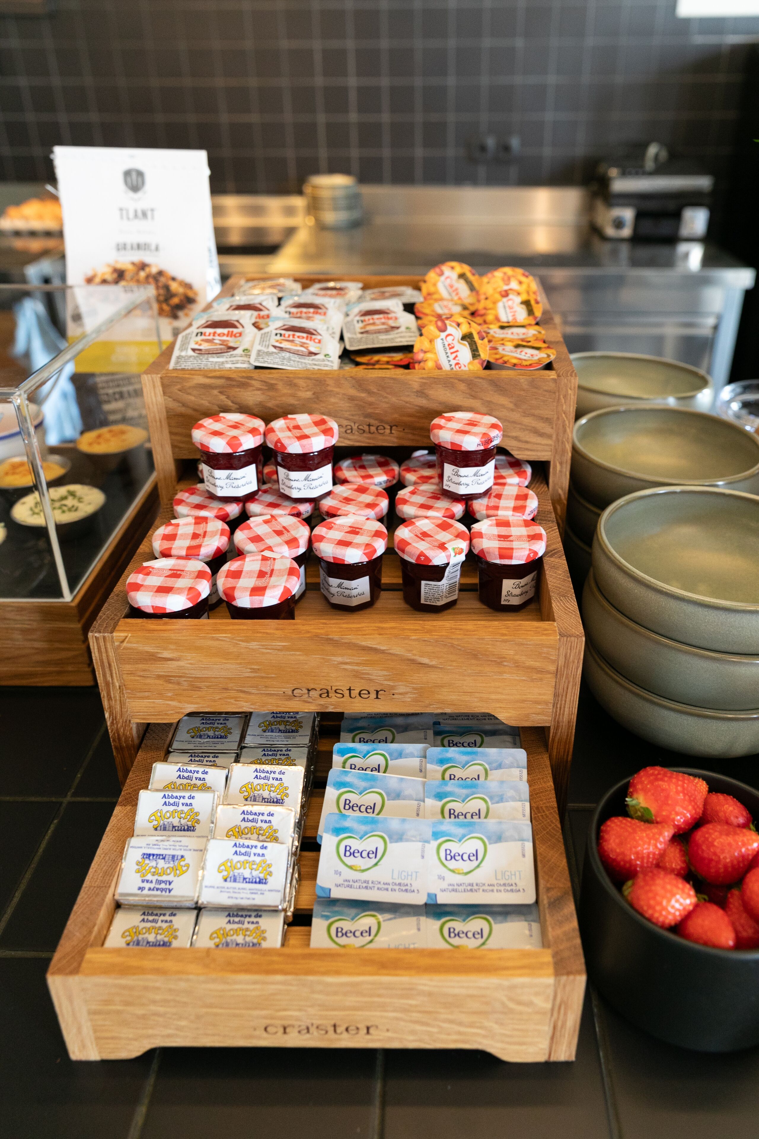 Una exhibición de diversos alimentos, entre ellos, frascos de mermelada, barras de chocolate y productos de snack envasados.