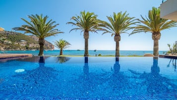 Piscine extérieure, parasols de plage, chaises longues