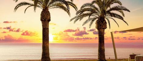 Een buitenzwembad, parasols bij het zwembad en ligstoelen