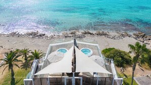 A beachside view from a balcony with a pool, palm trees, and a clear view of the ocean. - Melbeach Hotel & Spa - Adults Only (Capdepera)