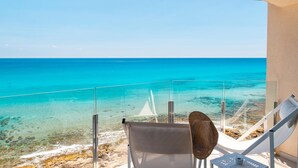 A balcony with a clear view of the turquoise sea, a white lounge chair, and a small table. - Melbeach Hotel & Spa - Adults Only (Capdepera)