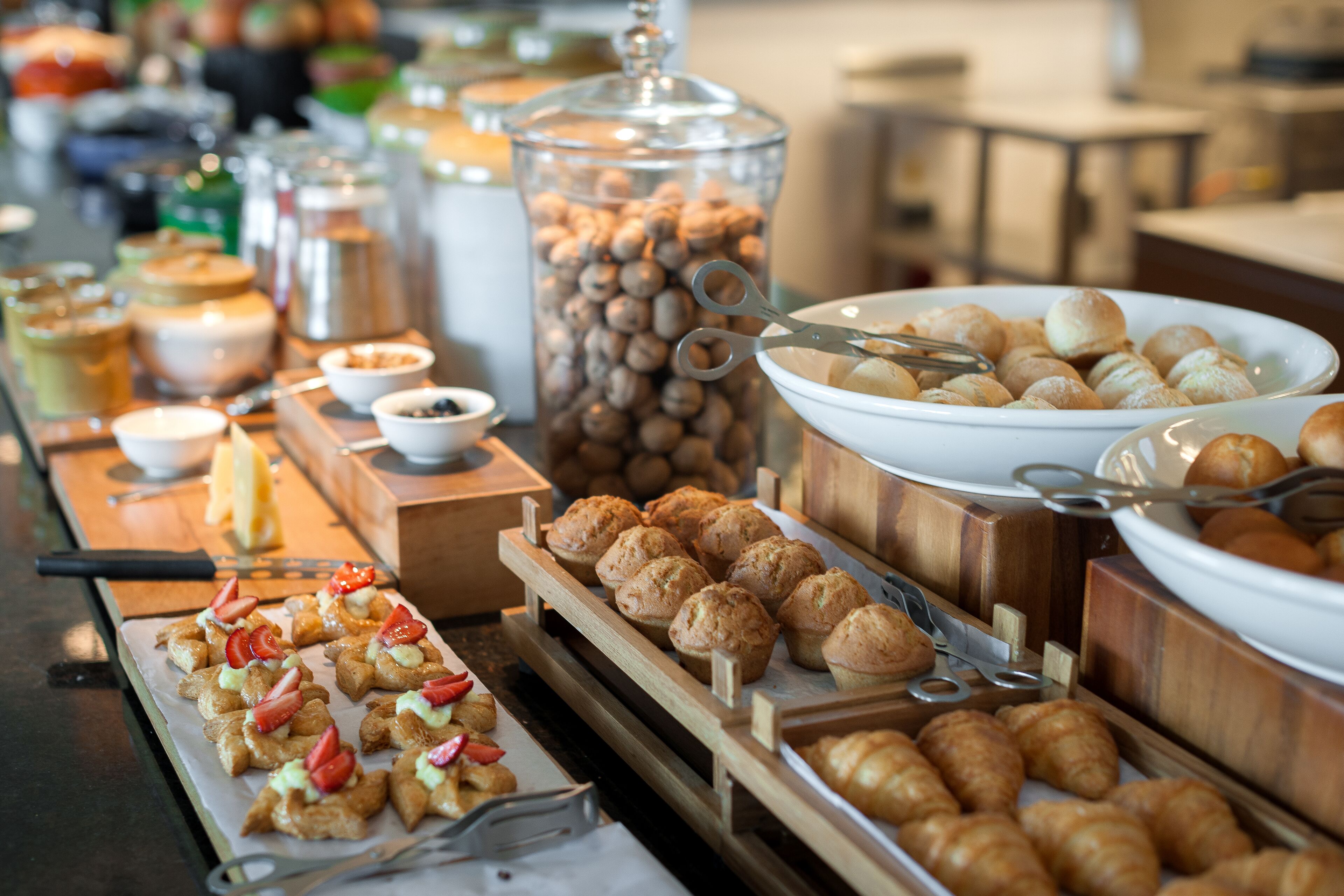 Un buffet proposant une variété de plats, notamment des pâtisseries, des fruits et des boissons.