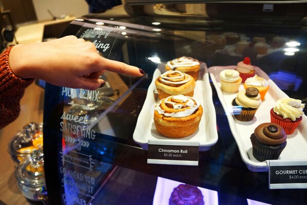 Una selección de pasteles con etiquetas que muestran los precios.