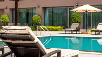 Relax by the pool with lounge chairs and a shaded area.
