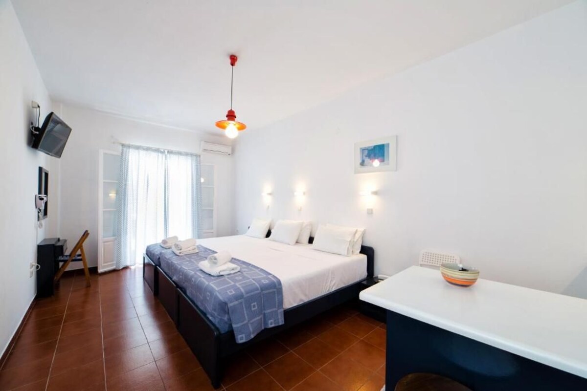 Une chambre à coucher avec un lit, une table de chevet et un téléviseur fixé au mur.