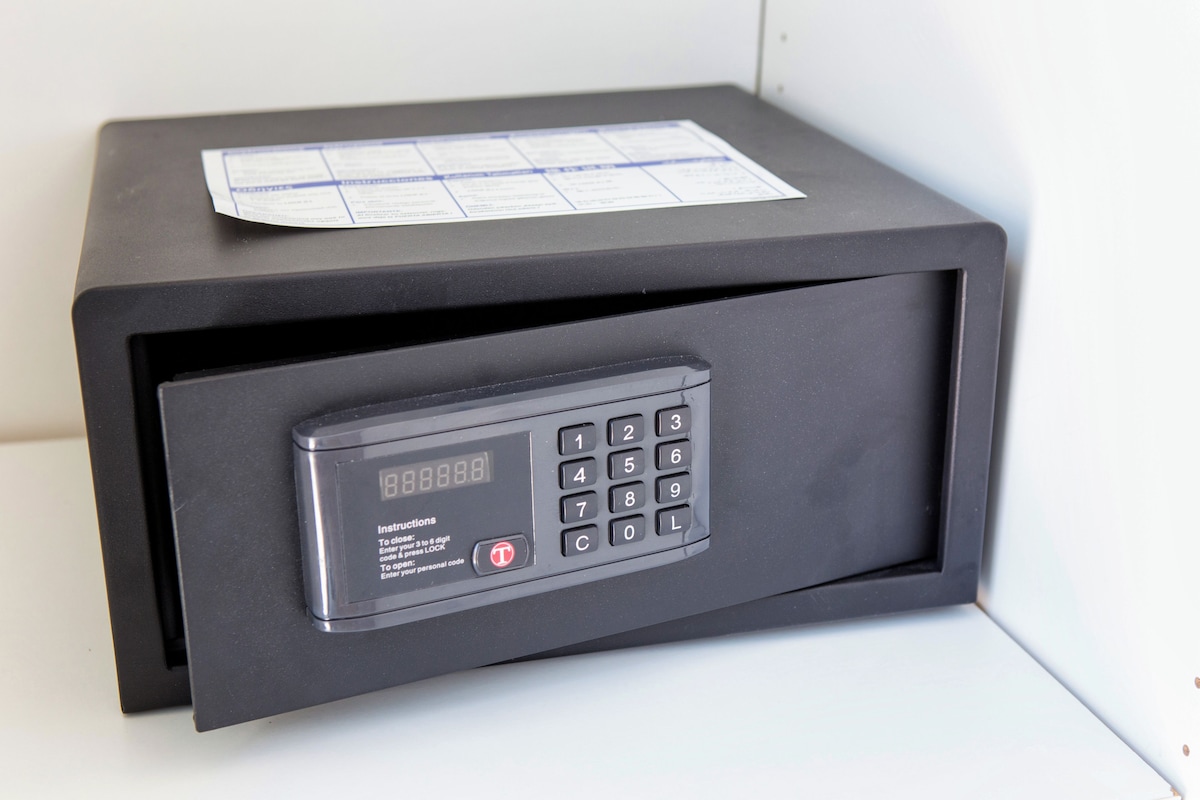 A black safe with a keypad and a paper on top.