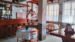 Un restaurante acogedor con mobiliario de madera, una zona de bar y una chimenea de piedra.