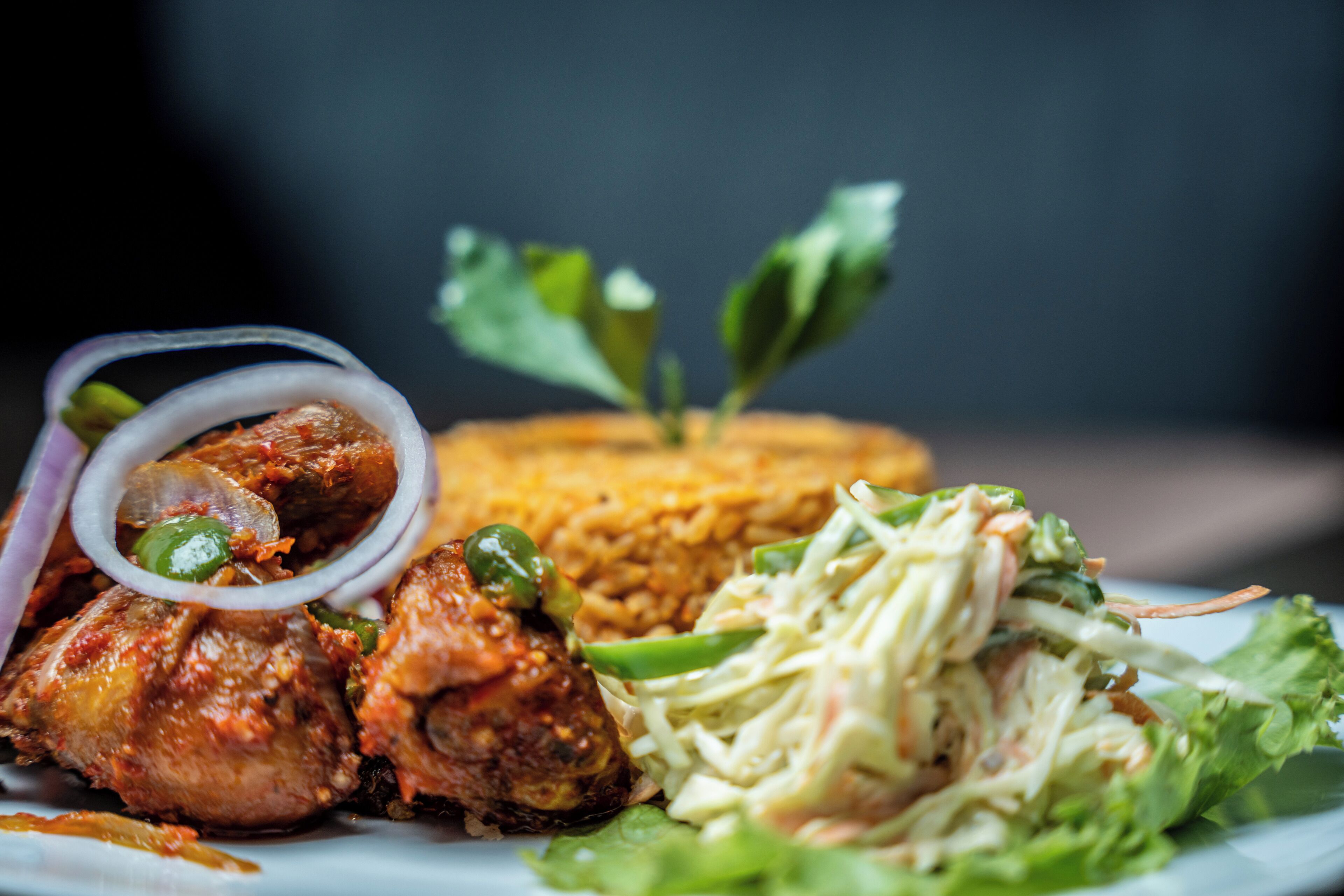 A plate with grilled chicken, rice, and a side salad.