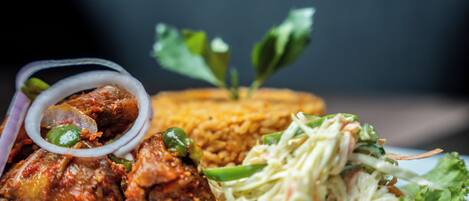 A plate with grilled chicken, rice, and a side salad.