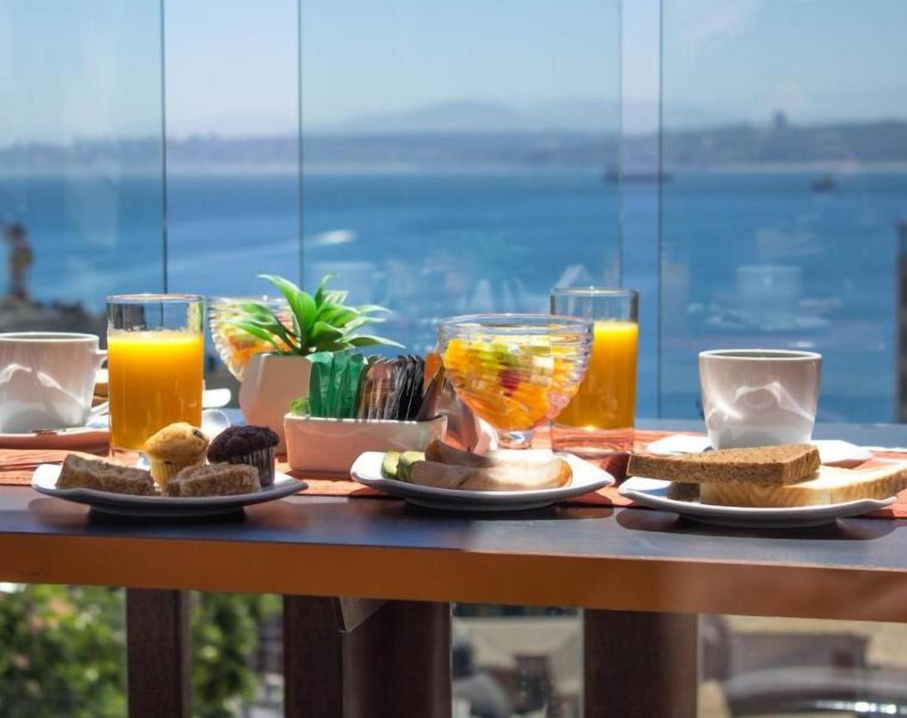 A breakfast setting with a view of the sea and boats.