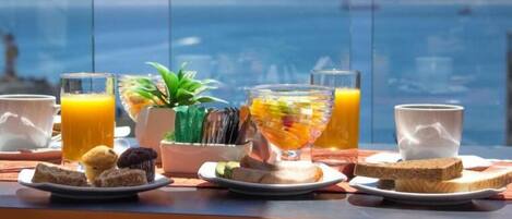 A breakfast setting with a view of the sea and boats.