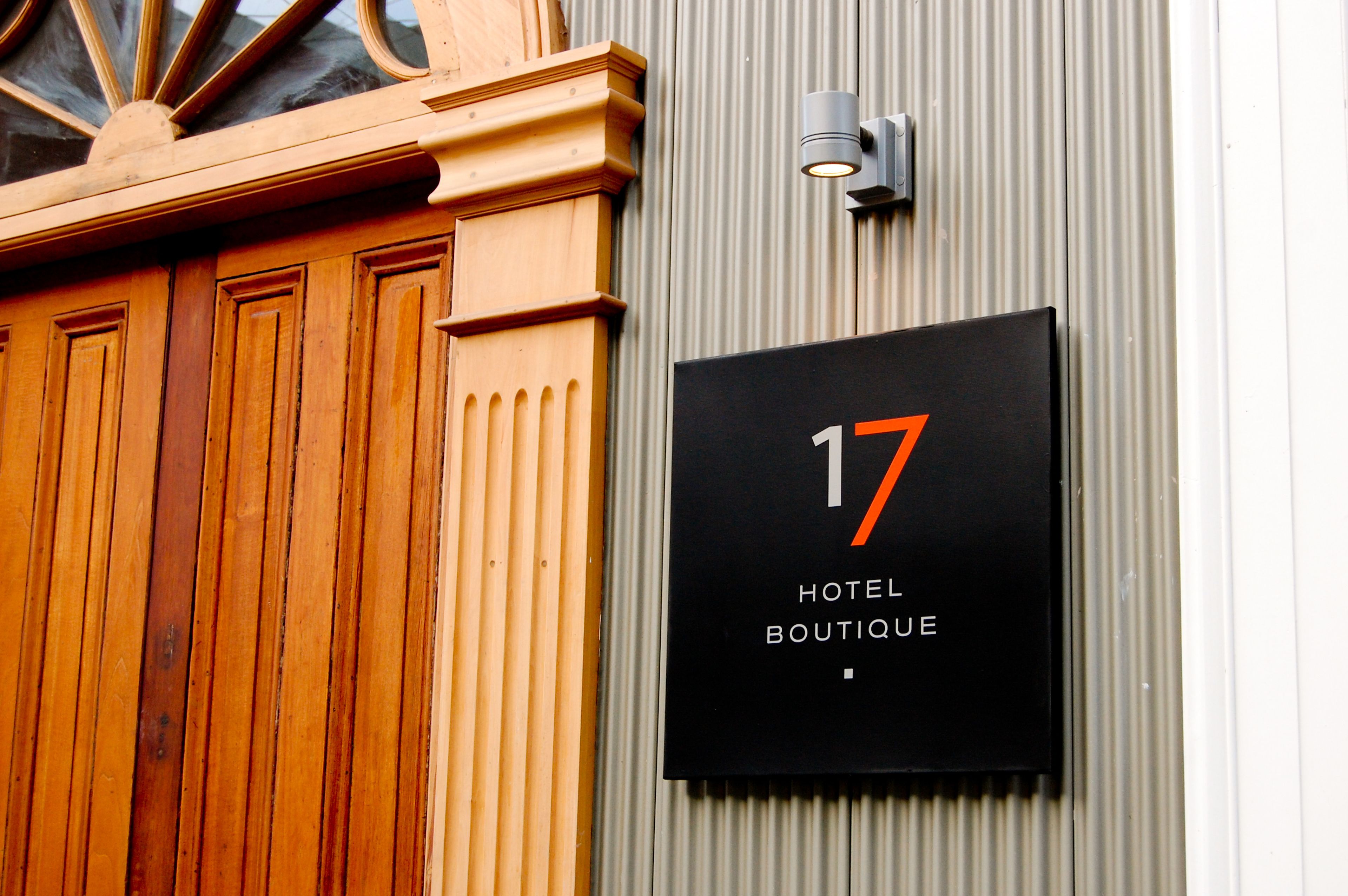 Segnaletica di un hotel con il numero 17 e la scritta 'HOTEL BOUTIQUE' su sfondo nero.