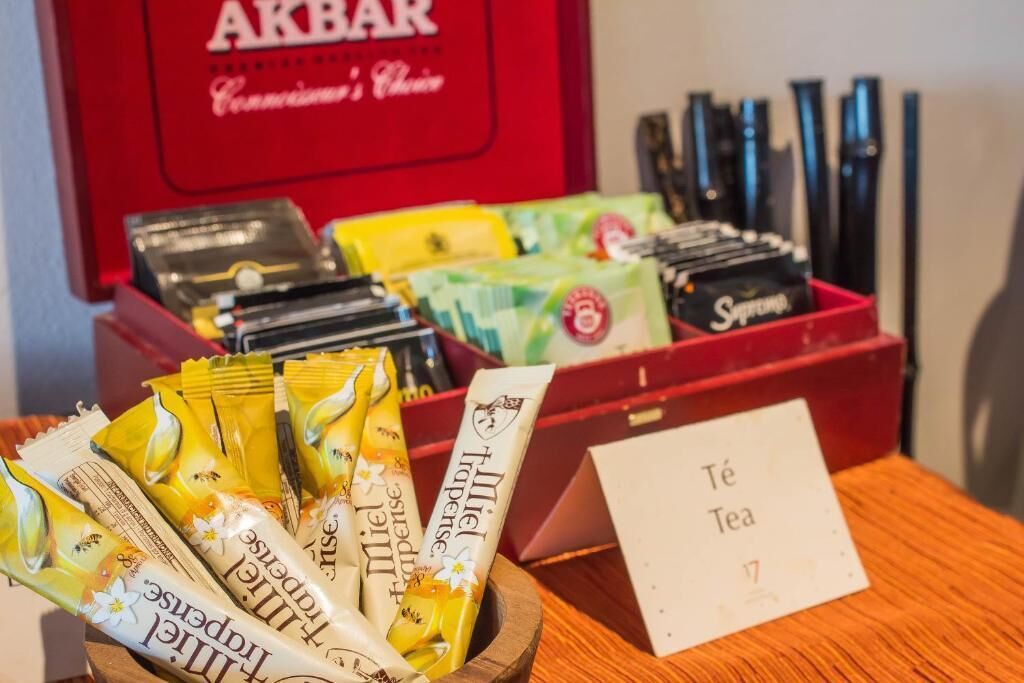 Une sélection de produits à base de thé présentée dans un bol en bois sur une table, avec une pancarte indiquant « Té Tea ».