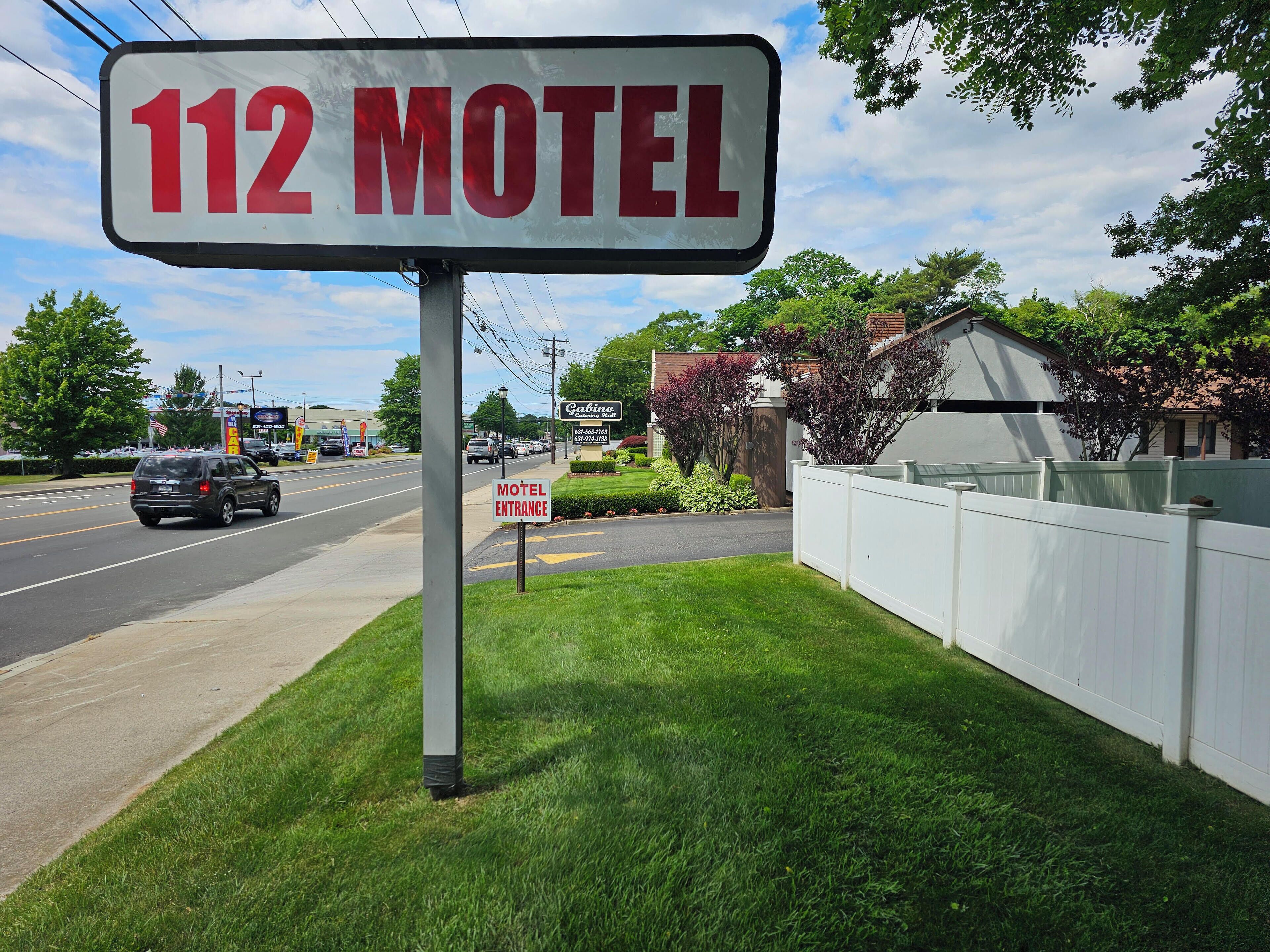 Een motelteken met het nummer 112 en het woord 'Motel' in rode letters.