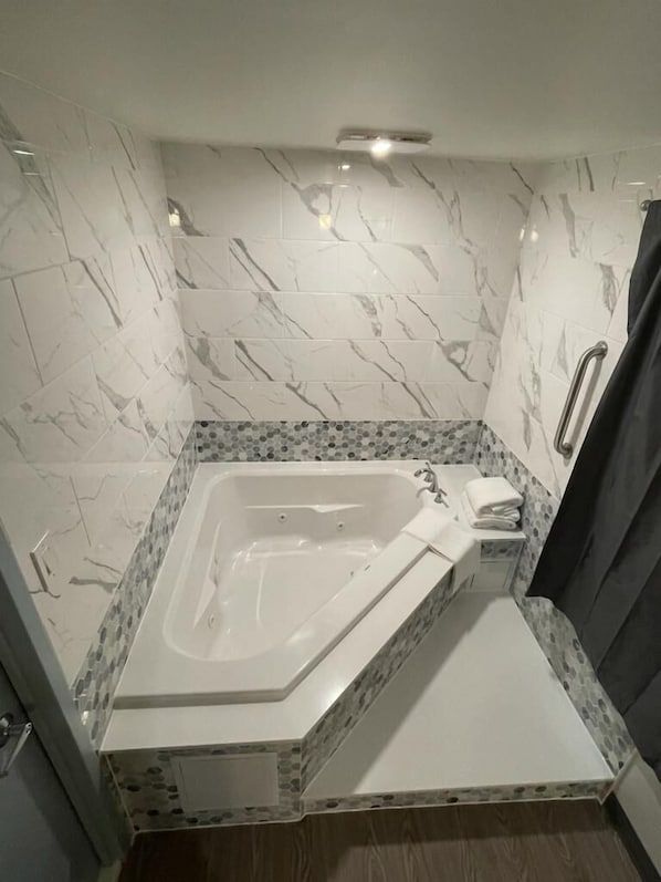Habitación romántica, 1 cama King size, hidromasaje | Área de sala de estar | Smart TV de 50 pulgadas con canales vía satélite y televisión