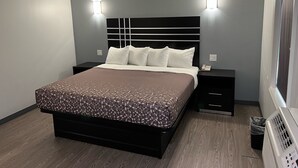 Um quarto moderno com uma cama grande, mesas de cabeceira e aquecedor fixado na parede.
