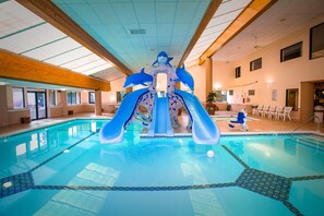 Ein Hallenbad mit Delfinschleife und Sitzbereich mit Stühlen.