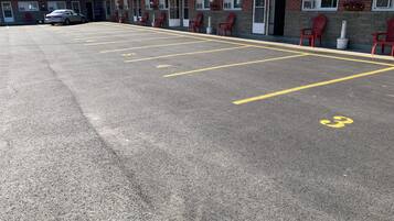 Un motel doté d’un parking délimité par des lignes jaunes et dont les places de stationnement sont numérotées.
