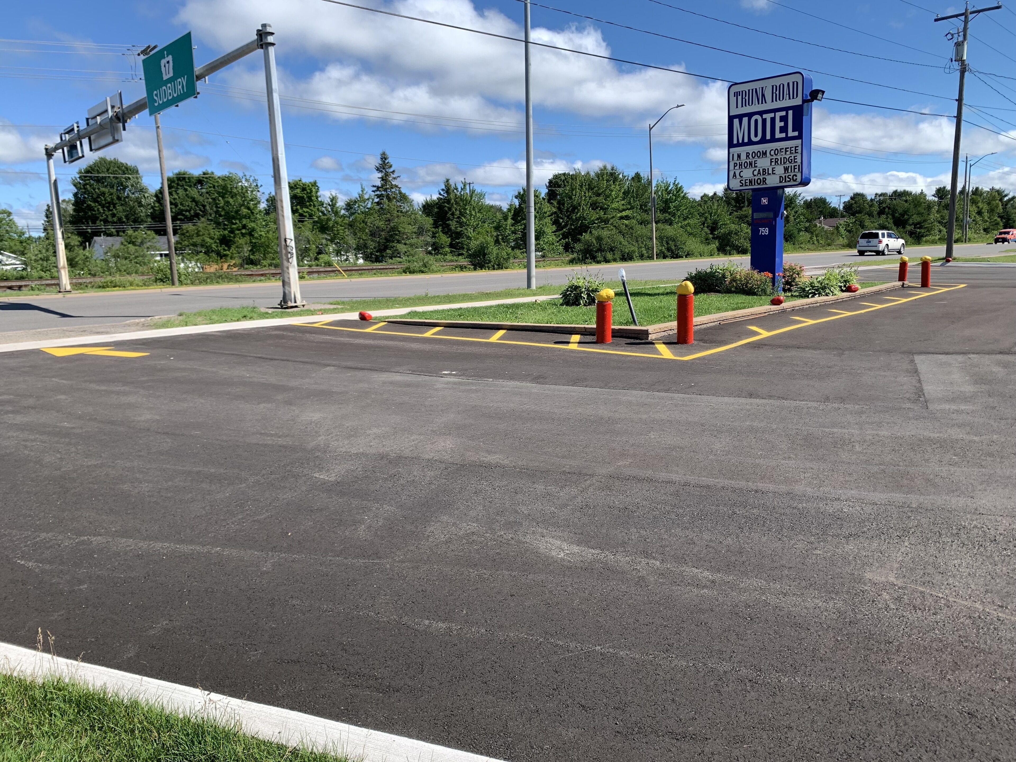 A motel sign with amenities including room coffee, phone, fridge, AC, cable wifi, and senior discount.