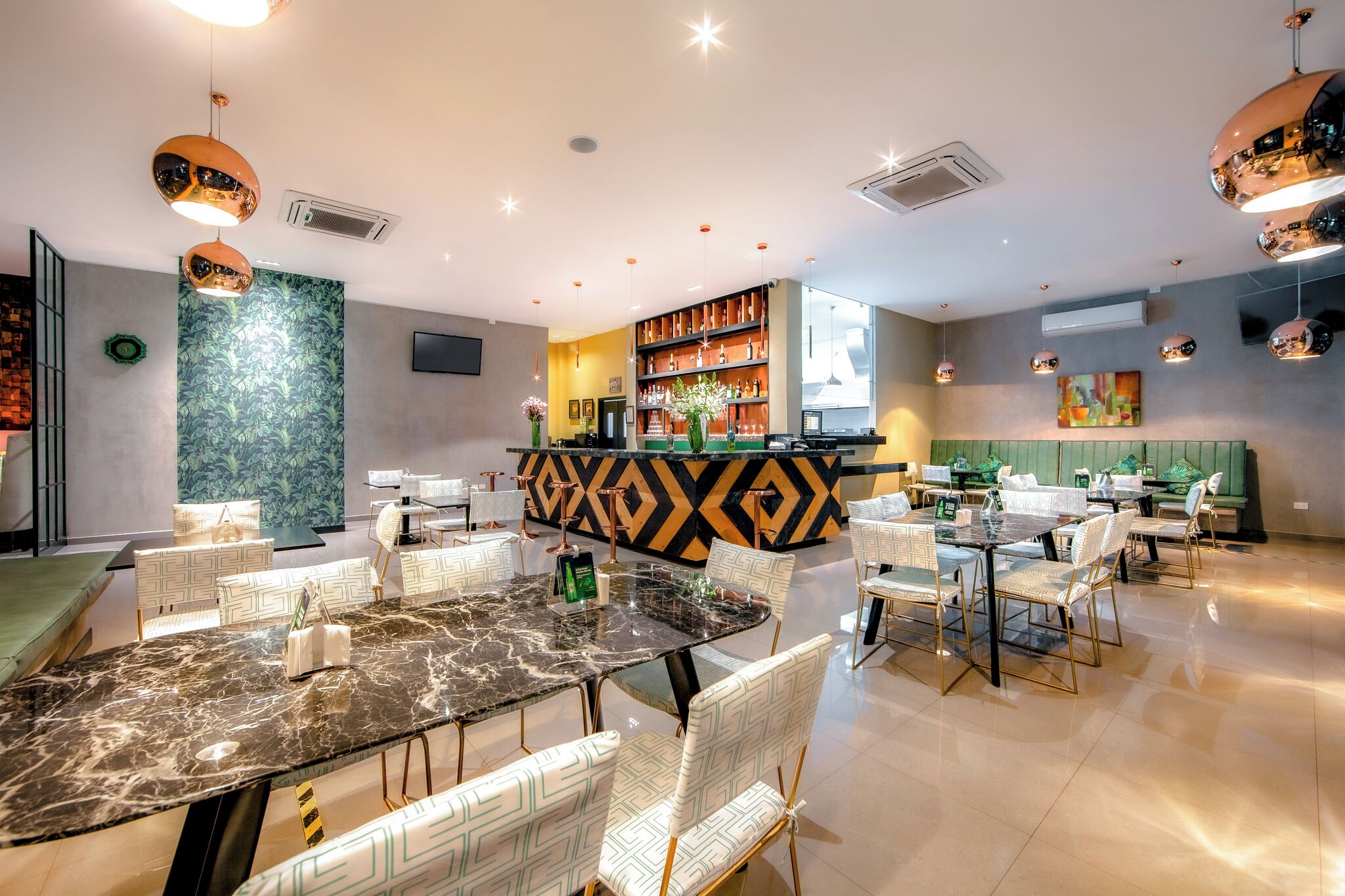 Un restaurante moderno con barra central, sillas blancas con estampado y una mesa de mármol.
