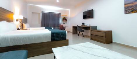 Una habitación de hotel moderna con cama, escritorio, silla y televisor en la pared.