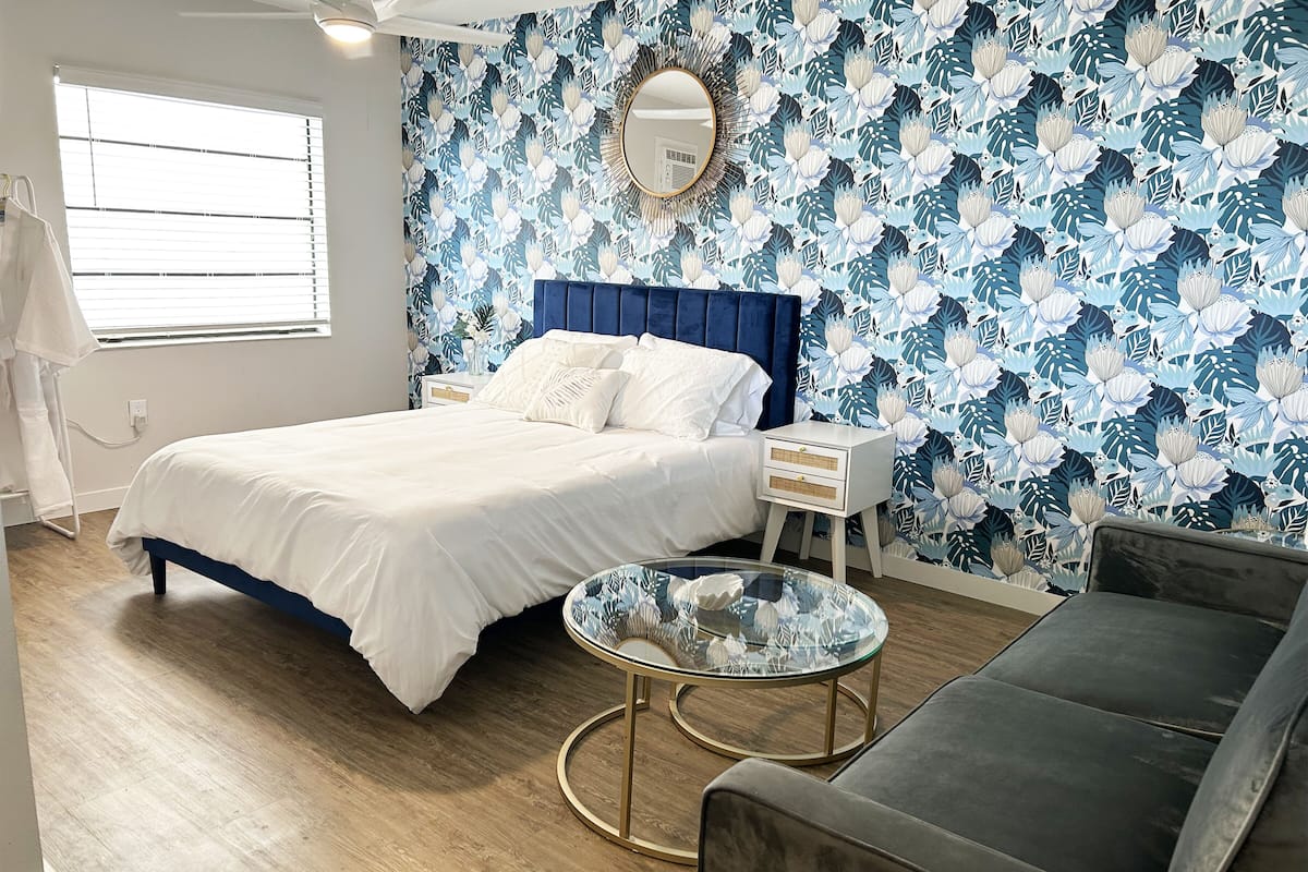 A bedroom with a bed, bedside table, and a glass coffee table.
