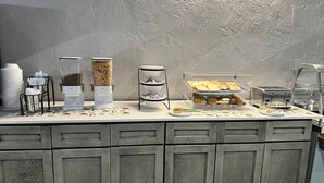 A buffet setup with various food items and a coffee station.