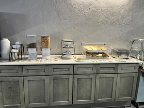 A buffet setup with various food items and a coffee station.