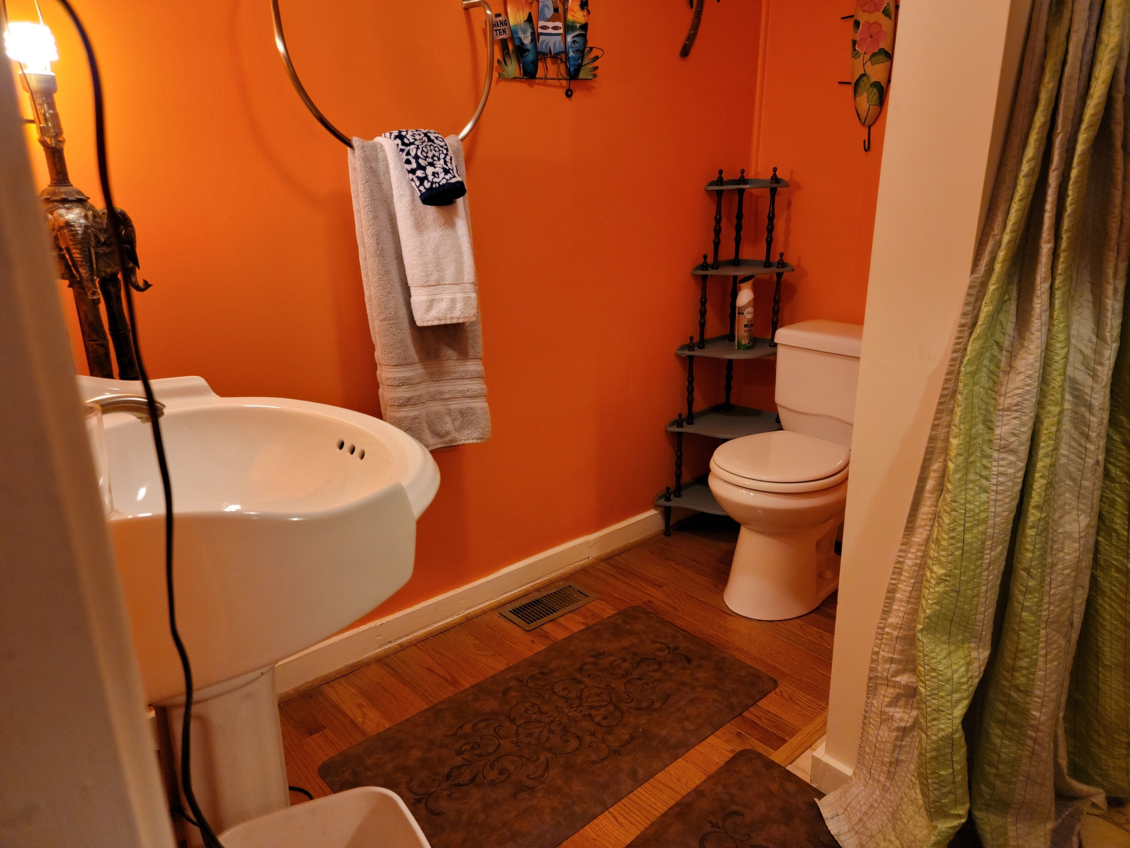 Une salle de bain avec un lavabo blanc, des toilettes et un porte-serviettes.