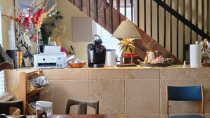 Un comptoir de cuisine avec une machine à café, une lampe et divers ustensiles de cuisine.