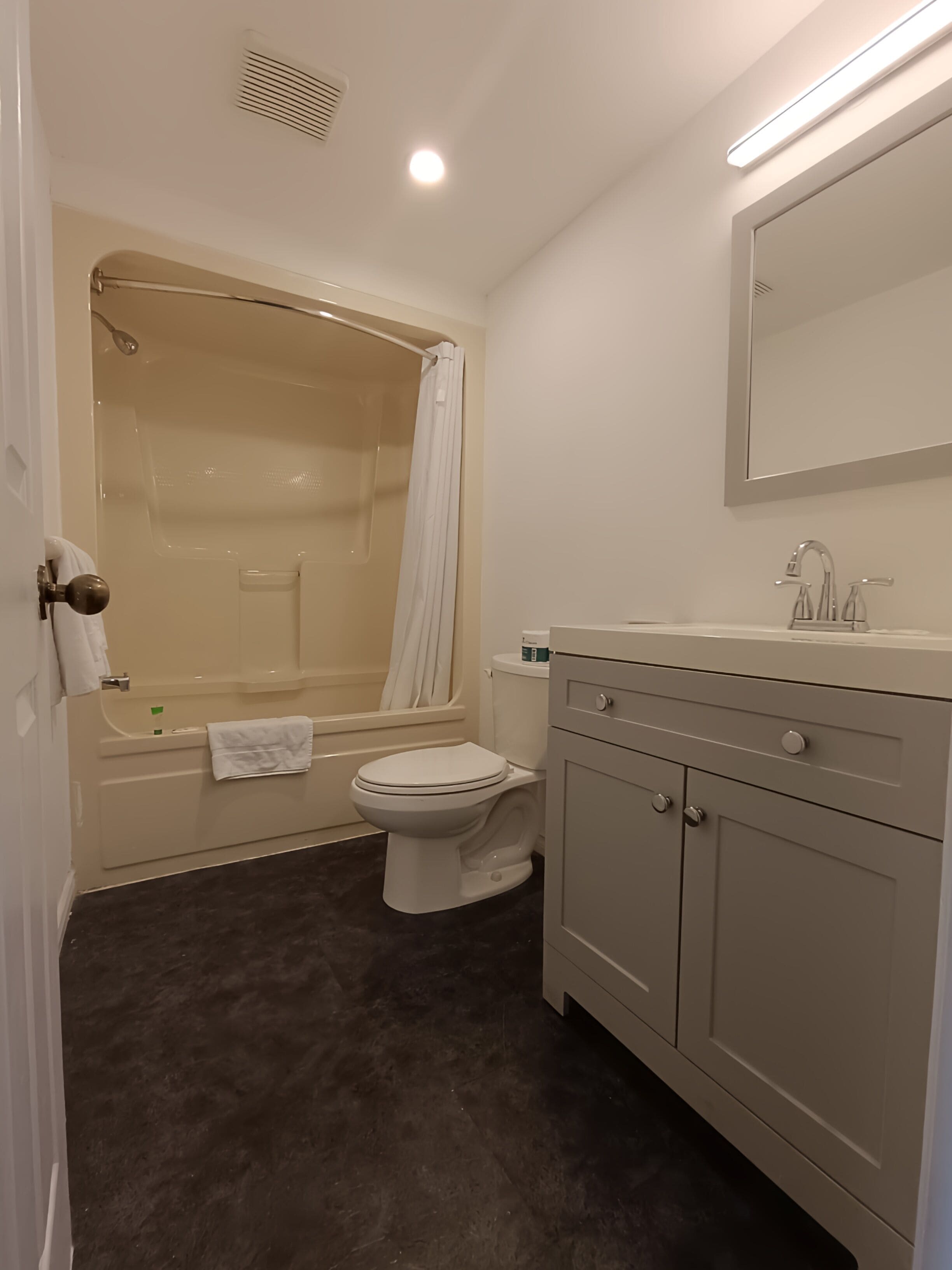 A bathroom with a bathtub, toilet, and vanity.