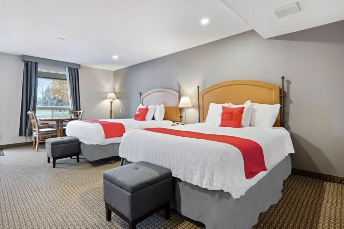 Ein Hotelzimmer mit zwei Betten, einem Schreibtisch und einem Sessel.