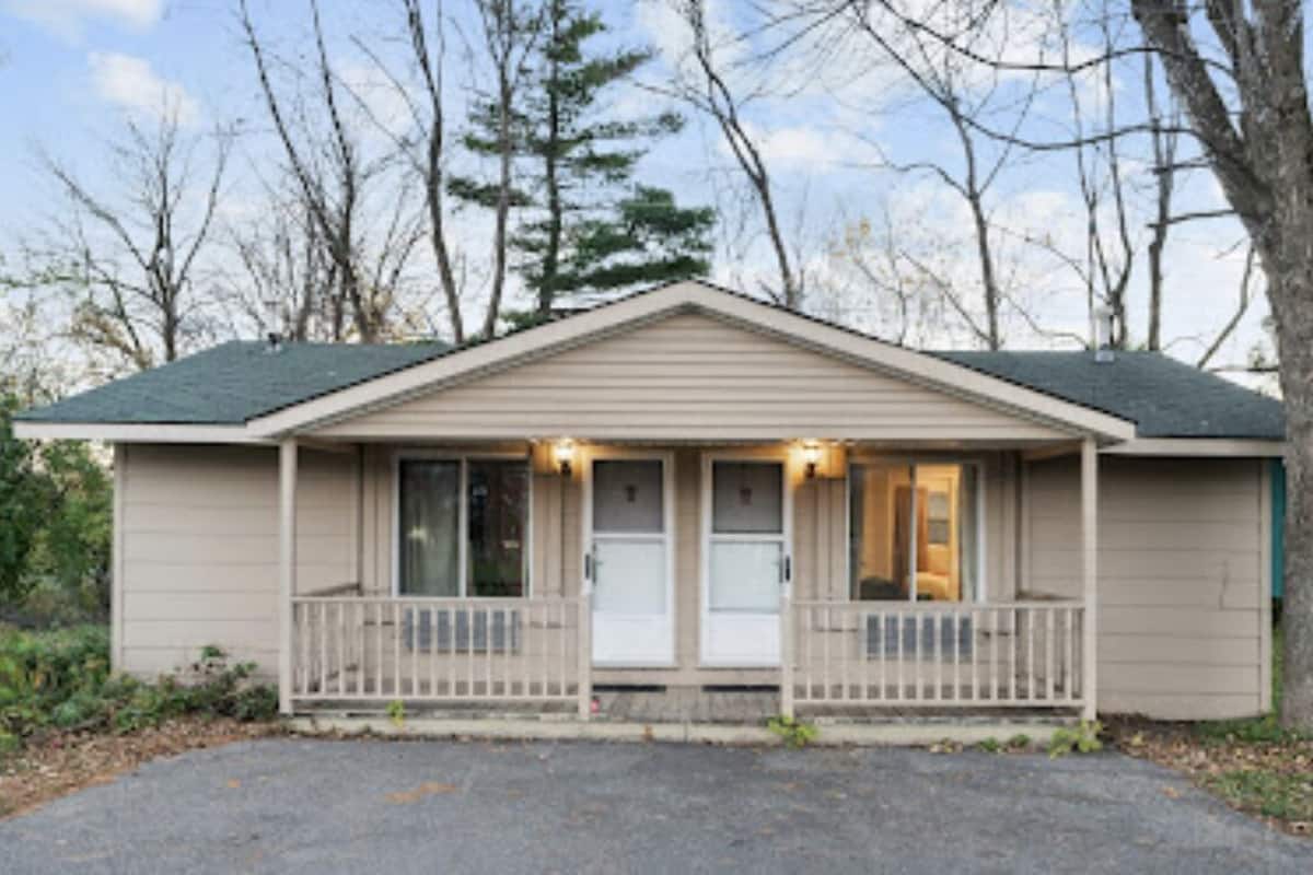Einbungalow mit Veranda, Garage und kleinem Vorgarten.