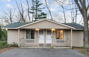 A single-story house with a front porch, a garage, and a small front yard.