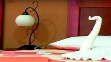 Una cama con almohadas blancas y un cisne decorativo.